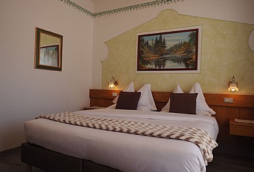 Hotel 3 stelle a Canazei (***) a Canazei. Lato sud con vista sulla valle di Fassa. Arredamento sobrio con letti sommier in semilpelle e 4 cuscini. Scrivania, TV a schermo piatto, cassaforte, telefono e ciabattine. Balcone con sedia.
Bagno privato con vasca, bidet, phon e set di cortesia.